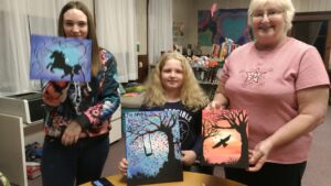 Family holding paintings